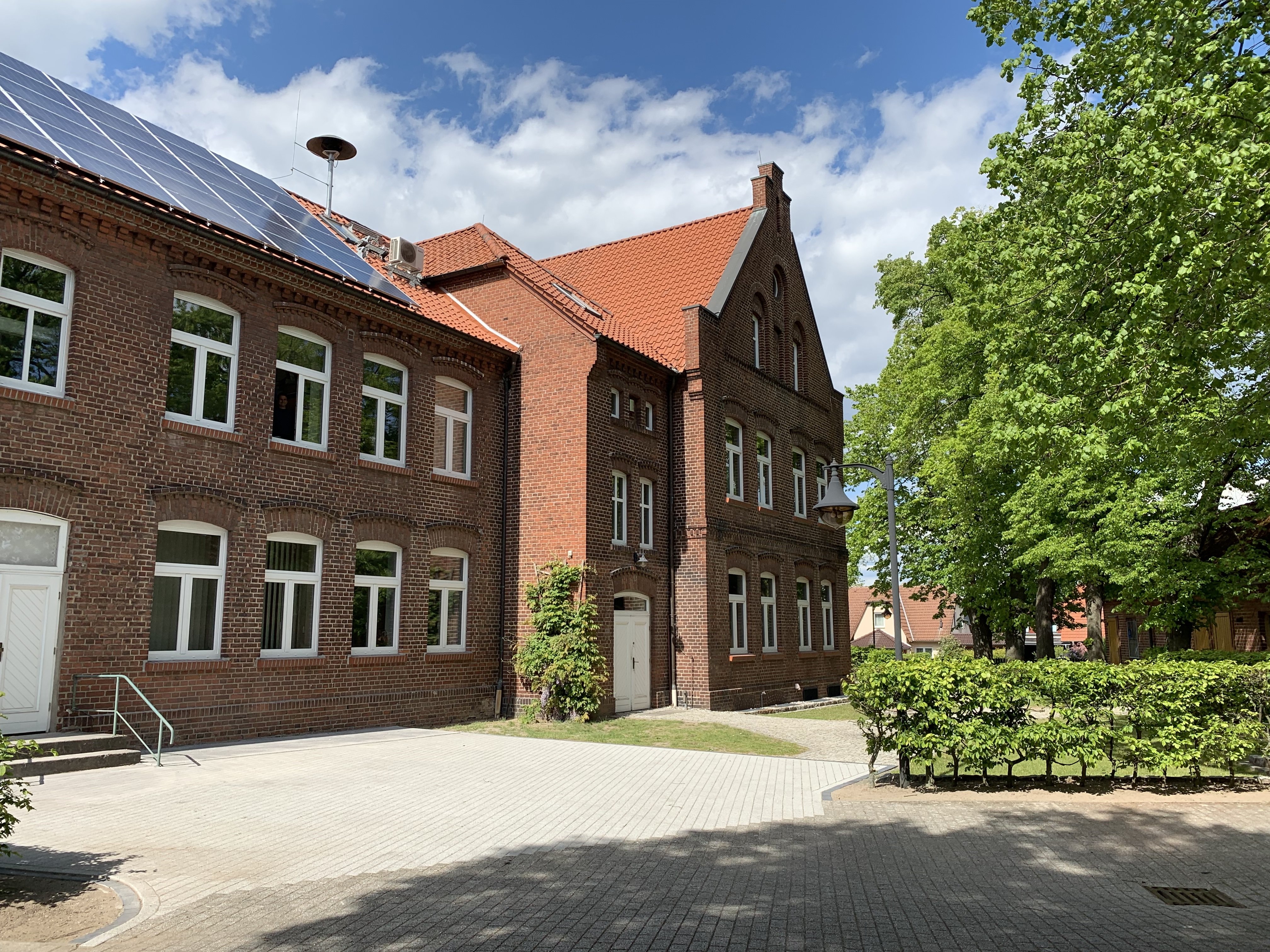 Gemeindezentrum von Elbe-Parey. Zweistöckiges Haus, rote Ziegel, Schrägdach.